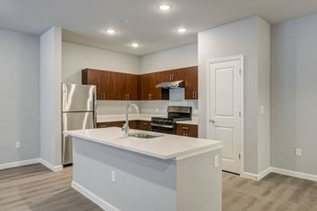a kitchen with an island and a stainless steel refrigerator